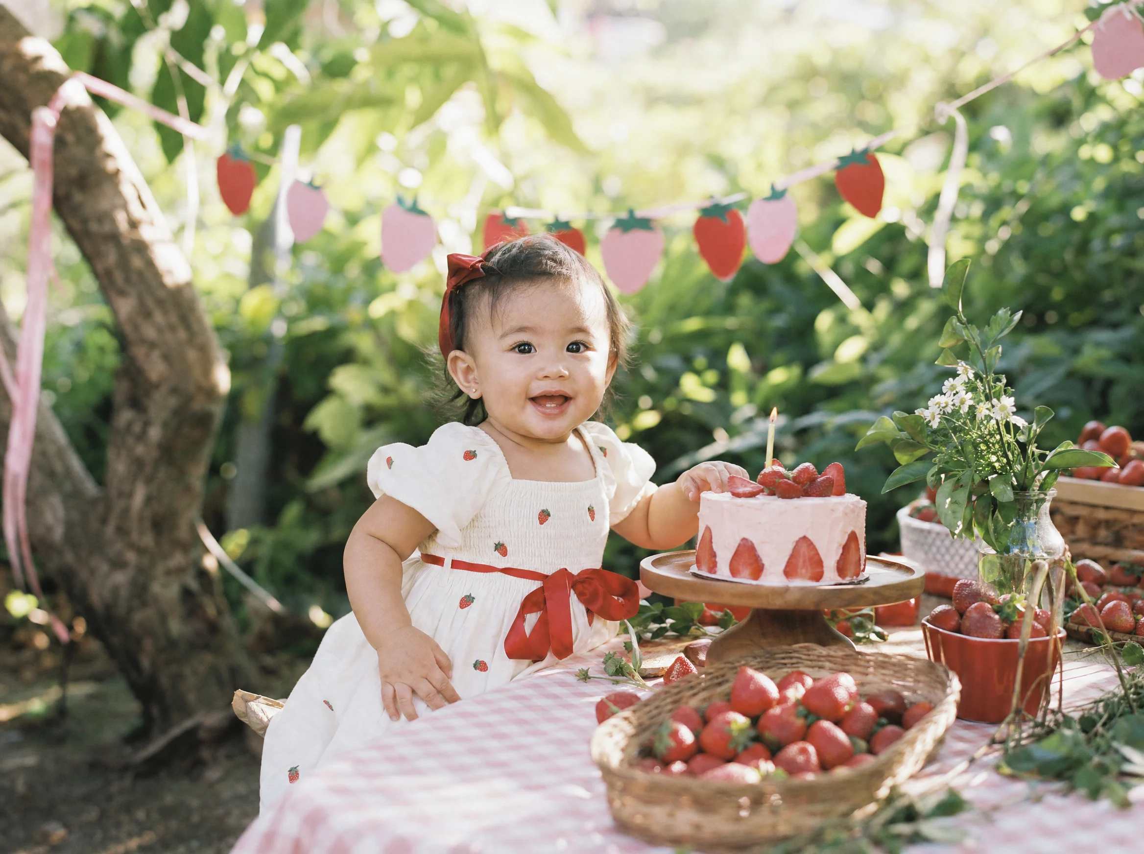 Mila celebrating her first birthday with strawberries and cake